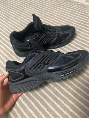 Svarta Pegasus Wave sneakers - Snygga helsvarta Pegasus Wave sneakers med sportig design. Skorna har meshpaneler för andningsförmåga, detaljer i blank plast och texten 'FULL LENGTH NIKE AIR' på sulan. Lågt skaft och snörning framtill. Perfekta för en streetwear-look.