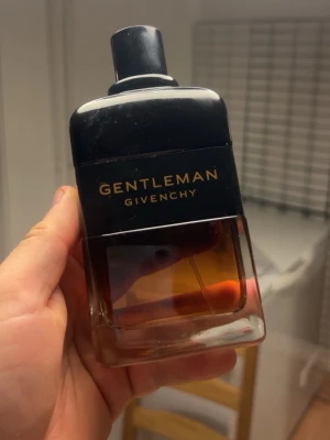Givenchy Gentleman Reserve Privee parfym 200 ml med kvitto - Kvitto finns, säljes pga många parfymer. Givenchy Gentleman parfym i en stilren glasflaska med svart lock och svart etikett med guldfärgad text. Flaskan har en snygg gradient från mörkt till ljust brunt. Rymmer 200 ml och har en exklusiv och modern design.