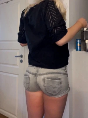 Lågmidjade jeansshorts  - Snygga grå jeansshorts med dubbla knappar i midjan och uppvikta benslut. Shortsen har klassiska fickor fram och bak samt en lågmidjad passform. Perfekta för varma sommardagar och ger en avslappnad look. 