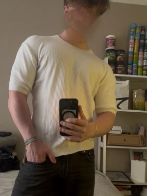 Vit ribbad t-shirt med kort ärm - Säljer en stilren vit t-shirt med ribbad struktur och korta ärmar. T-shirten har en klassisk passform och rund halsringning, perfekt för en clean och enkel look. Materialet känns mjukt och följsamt mot kroppen. Från märket H&M