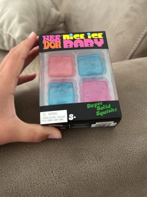 Nee Doh Nice Ice Baby squishies - Fyra färgglada squishies från Nee Doh i serien Nice Ice Baby. Två rosa och två blå, formade som isbitar och förpackade i en svart låda med färgglad text. Perfekt för stresslindring eller som rolig leksak. Jag tar gärna emot bud. 