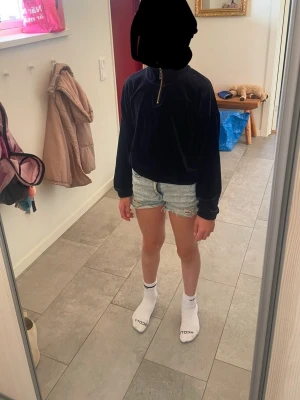 Mörkblå tjocktröja med dragkedja - Mysig mörkblå tjocktröja med halv dragkedja i halsen och långa ärmar. Tröjan har en avslappnad passform och är perfekt för en chill och bekväm stil. Passar bra till jeans eller shorts. Nästan inga tecken på användning.