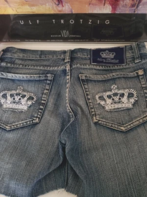 Victoria Beckham Jeansshorts 28" Rock & Republic rhinestones - Säljer ett par blå jeansshorts från Victoria Beckham med slitna kanter och snyggt tvättad look. rhinestones på bakfickorna str S/M -- 28" för Rock & Republic rhinestones shorts mått se bilder jätte fint skick  ♥️ 