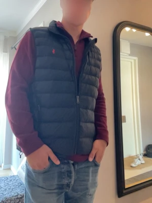 Vinröd halvzip tröja Polo Ralph Lauren - Vinröd långärmad tröja från Polo Ralph Lauren med halv dragkedja och hög krage. Tröjan har broderad logga på bröstet och är gjord i mjukt bomullsmaterial. Perfekt för en stilren och avslappnad look.