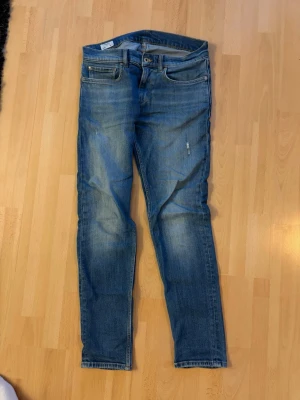 Slim fit jeans med slitningar W31  - Snygga blå jeans i slim fit med lätt slitna detaljer och klassisk femficksdesign. Jeansen har en något ljusare tvätt på låren och knäna för en cool look. Perfekta till vardags och passar till det mesta. Storleken på bild motsvarar W31 L32 