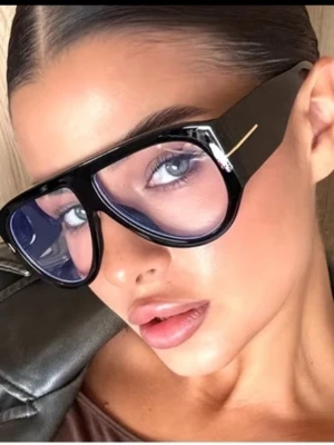 Svarta oversized solglasögon - Säljer ett par svarta oversized solglasögon med markerad båge och transparenta linser. Glasögonen har en cool retrovibe och en guldfärgad detalj på sidan av bågen. Perfekta för dig som vill sticka ut och addera edge till din look.
