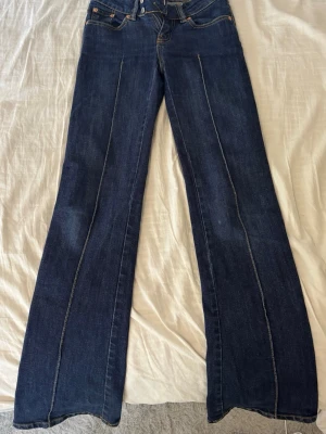 Mörkblå bootcut jeans från 157 - Säljer ett par mörkblå jeans från 157 med utsvängda ben och markerade sömmar framtill. 