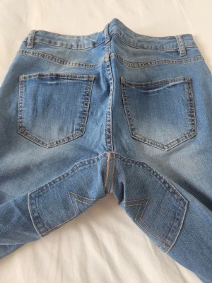 Unika baggy Y2K jeans låg midja broderade remake upcycled KappAhl strl 36-42 - Strl 36/38: Ger en cool, mer oversized och baggy Y2K-look (snyggt med bälte). * Strl 40: Sitter skönt avslappnade på höften. * Strl 42: Passar också tack vare stretchen, men blir då mer figurnära               * Hela längden / Total length: 85 cm * Innerbenslängd / Inseam: 66 cm * Midjehöjd / Rise: 21 cm (Låg midja / Low rise) * Midjemått / Waist: 41 cm * Brand: KappAhl (Remake / Upcycled by me) * Material: 98% Cotton, 2% Elastane (nice strech)