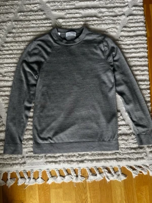Grå stickad tröja - Grå stickad tröja i merino ull från märket selected homme Längd (hals till midja): 67 cm Bredd: 46 cm Hör gärna av dig om du är intresserad eller har frågor!