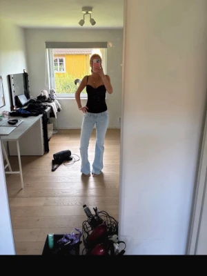 Lågmidjade jeans 14+ tall  - Säljer ett par ljusblå jeans med bootcut passform och hög midja. Jeansen har klassisk femficksdesign och är tillverkade i ett denimtyg som ger en snygg och avslappnad look. Perfekta till en enkel topp eller hoodie. Inga defekter då de används ca 3 gånger 