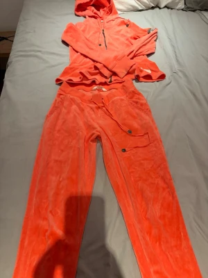 Korallfärgad mysdress från Odd Molly - Mysigt loungewear-set i korallfärg från Odd Molly. Setet består av en hoodie med dragkedja och fickor samt matchande byxor med dragsko och fickdetaljer. Perfekt för chill dagar hemma. Supersöt!! 