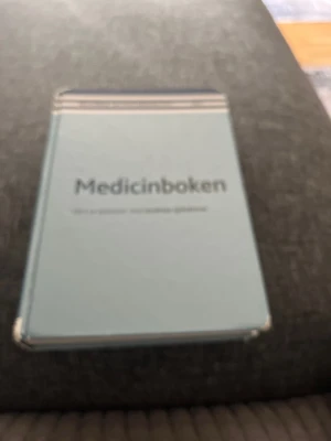 Medicinboken ljusblå kurslitteratur - Säljer 'Medicinboken', en kursbok med ljusblått hårt omslag och tydlig titel på framsidan. Perfekt för dig som pluggar medicin eller vårdrelaterade ämnen. Boken har ett stilrent och enkelt utseende med vita och grå detaljer.