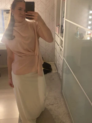 Ljusrosa omlottopp med knytband - Säljer en ljusrosa omlottopp med snygg knytning i midjan och korta ärmar. Toppen har en lös passform och hög hals. Perfekt att styla med kjol eller byxor för en chic look. Den är ifrån märket cider i storlek m men passar mig perfekt som är s❣️❣️