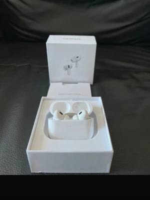 Apple AirPods Pro trådlösa hörlurar - Säljer ett par vita Apple AirPods Pro med laddningsetui. De är trådlösa in-ear-hörlurar med stilren design och silikonproppar för bra passform. Kommer i originalförpackning. Perfekta för musik, samtal och träning.