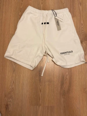 Kräm vita Essentials Shorts - Säljer dessa HELT NYA essentials shortsen i storlek M, tveka inte att dm vid frågor eller funderingar 