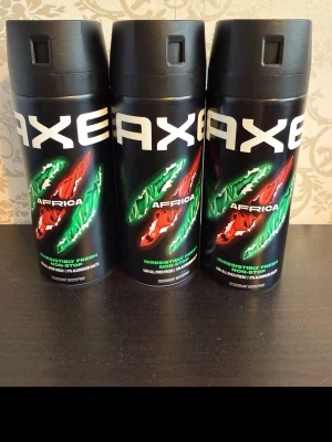 Axe Africa deodorant spray 3-pack - Tre stycken Axe Africa deodorant body spray med svart flaska och färgglad design i grönt och rött. Ger en fräsch och intensiv doft. Perfekt för dig som vill ha en långvarig och fräsch känsla hela dagen.