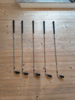 Golfklubbor spalding 6-pw - Säljer ett set med fem golfklubbor från spalding, modell Selective. Klubborna har silverfärgade skaft och svarta handtag med röda och vita detaljer på klubbhuvudet. Perfekt för dig som vill börja spela golf eller behöver komplettera din samling. Endast använda lite mindre än en säsong. Några små skador men inget som påverkar ditt spel! PRIS KAN DISKUTERAS! Hör av dig vid frågor