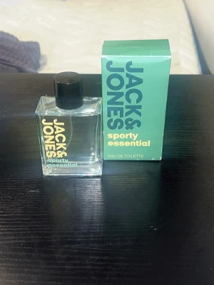  Jack & Jones Sporty Essential – Eau de Toilette (ART10) - En lättburen och sportig doft som passar perfekt till vardags. • Beskrivning: Jack & Jones Sporty Essential. En pigg och fräsch doft som ger en ren känsla hela dagen. Kartong ingår och flaskan är i nyskick. Mycket parfym för pengarna! • Mängd: 98ml •