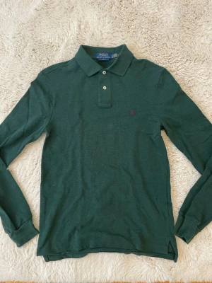 Grön långärmad piké Polo Ralph Lauren - Tjena säljer denna mörkgrön långärmade pikén från Ralph Lauren. Helt ny fick i julklapp men har aldrig kommit till användning. Kontakta vid funderingar! Öppen för prisförslag!