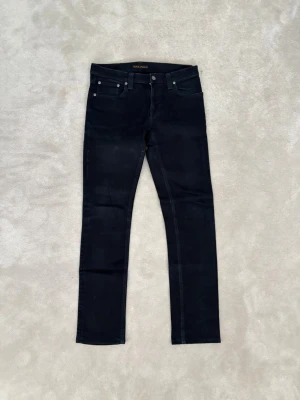 Svarta Nudie Jeans Tube Kelly: W29 L34 - Snygga svarta skinny jeans från Nudie Jeans med klassisk femficksdesign och smal passform. Perfekta för en stilren och modern look. Använda få gånger.