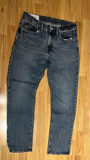 Mörkblå raka jeans med vintage-look från H&M - Säljer ett par mörkblå jeans med rak passform och klassisk femficksdesign. Jeansen har en snygg vintage-wash och är tillverkade i denim. Perfekta för dig som gillar en tidlös och avslappnad stil. MVH✌️ 