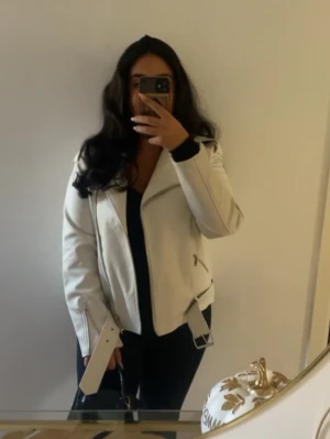 Oversized boyfriend biker jacket  - Snygg krämvit oversized skinnjacka i bikerstil från nelly. Silverfärgade dragkedjor och ett matchande bälte i midjan. Passar perfekt till kostymbyxor, jeans ellee klänning. Storlek 36. Passar storlek S och M då den är oversized.