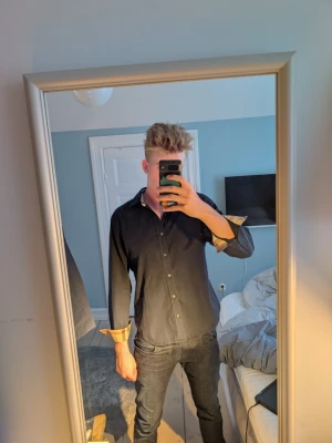 Svart skjorta från Burberry - En skjorta från Burberry. Det är toppen skick på skjortan. använd 2 gånger pga för liten. Om du har fler frågor är det bara att ställa🤝☺️ Skjortan passar garanterat folk i M