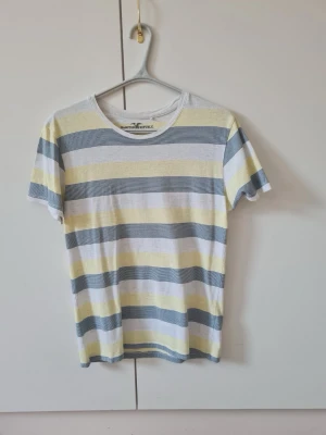 Randig t-shirt från Hampton Republic Kappahl strl S - Snygg t-shirt med breda horisontella ränder i vitt, grått och ljusgult från Hampton Republic Kappahl. Klassisk rund halsringning och korta ärmar. Storlek S.