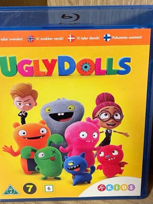 UglyDolls Blu-ray film - UglyDolls Blu-ray med färgglad framsida och animerade figurer. Filmen är på svenska, norska, danska och finska och passar för barn från 7 år. Omslaget är gult med flera tecknade monster i olika färger och former.