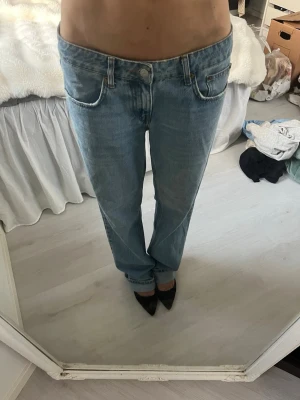 Ljusblå raka jeans - Säljer ett par ljusblå jeans med rak passform och klassisk femficksdesign. Jeansen har normal midja och stängs med knapp och dragkedja. Perfekta för en avslappnad och trendig look.