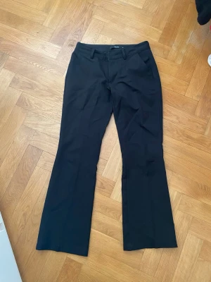 Svarta kostymbyxor - Säljer ett par svarta kostymbyxor bootcut i storlek 34 från bikbok