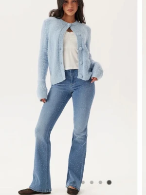 Ljusblå utsvängda jeans med glitter - Säljer ett par ljusblå jeans med utsvängda ben och små paljetter/ glitter över hela tyget. Jeansen har klassisk femficksmodell, normal midja och stängs med knapp och dragkedja. Perfekta för dig som vill ha en unik twist på dina jeans! Tror dom är från only men köpt på bubbleroom 