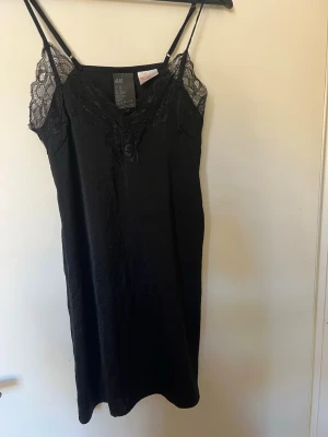 Svart spetsnattlinne från H&M - Snyggt svart nattlinne från H&M, perfekt med en kavaj och snygga skor för att bära upp som en klänning.