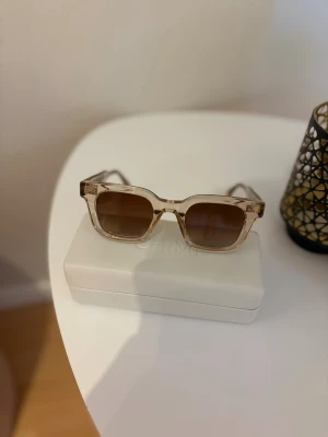 Beige chimi 04  - Säljer dessa chimi 04 beige solglasögon, då jag köpte dem för ca ett årsedan och använt dem ett få tals gånger så väljer att sälja dom till ett vanligt pris. Tyvärr har de kommit en liten fläck på fodralet som jag ej får bort, sätter lägre pris pga av detta, solglasögon är som nya