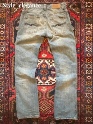 Nudie Jeans - Storlek W30/ L32, lite bootcut aktig Mycket bra skick, snygga slitningar runt fickorna. Ytterbenslängd: 103 cm Midja: 38,5 cm Benöppning: 19,5 cm