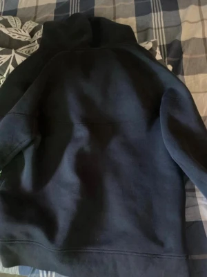 Svart Nike hoodie  - Säljer en svart hoodie från Nike med dragkedja framtill och två fickor med dragkedja. Hoodien har en sportig look, huva och är gjord i mjukt fleece-material. Perfekt för dig som gillar streetwear och enkel stil.