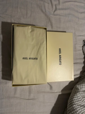 Svarta sneakers från Axel Arigato - Stilrena svarta sneakers från Axel Arigato i lågt modellutförande. Skorna har en minimalistisk design med ovandel i slätt läder och matchande svarta sulor. Perfekta för dig som gillar en clean och modern look.Har använt dom endast få tal gånger eftersom dom är lite stora.