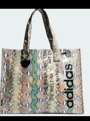 Adidas shoppingväska ormmönstrad - Säljer en snygg shoppingväska från Adidas.. Perfekt för dig som vill sticka ut med en trendig accessoar. Ordinarie pris 699kr