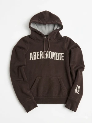 Vintage Abercrombie and fitch hoodie - Mörkbrun hoodie från Abercrombie & Fitch med vit logga på bröstet och siffrorna 1892 på ärmen. Hoodien har en stor huva med grått innerfoder, dragsko och en klassisk magficka. Tillverkad i mjukt bomullsmaterial, perfekt för en avslappnad stil. Storlek M men passar mer som S, skick 9/10