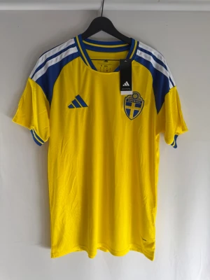 Sverige fotbollströja gul/blå 2026 - Rund hals med blå och gula detaljer, kort ärm och lätt, ventilerande material perfekt för träning eller match. 