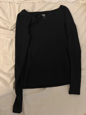 Svart basic långärmad  - En enkel svart t-shirt med rund hals och raka linjer. Perfekt för en clean och stilren look. T-shirten är i mjukt material och har korta ärmar. Passar till det mesta och är ett måste i garderoben.