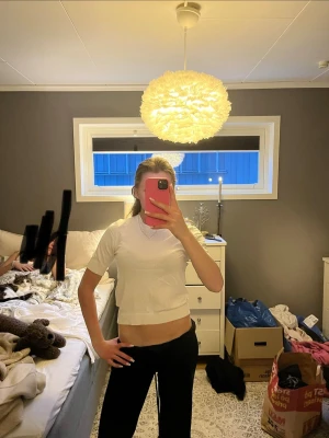 Vit stickad T-shirt - En enkel och stilren vit croppad t-shirt med korta ärmar och rund halsringning. Perfekt för en avslappnad och trendig look. Passar bra till både jeans och kjol.