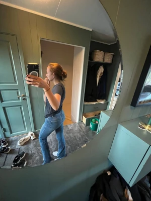 Blå bootcut jeans i klassisk modell - Säljer ett par blå bootcut jeans med hög midja och klassisk femficksdesign. Jeansen har en snygg tvätt och är tillverkade i ett stretchigt denimtyg som sitter bekvämt. Perfekta för dig som gillar en tidlös och avslappnad stil.