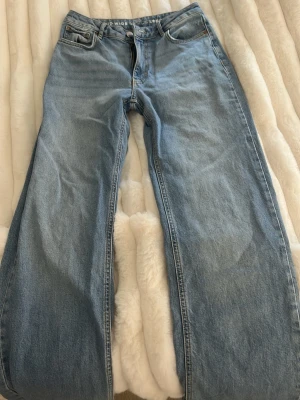 Blå raka jeans från bik bok  - Säljer ett par klassiska blå jeans från bik bok med rak passform och fyra fickor. Jeansen har normal midja och är tillverkade i denim av bomull. Perfekta för en avslappnad och trendig stil.