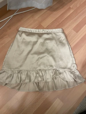 Beige kjol som slutar där knäna börjar  - Det är en beige kjol ifrån Lindex i storlek 146/152 jag har använt den få gånger och säljer för att den är liten för mig.