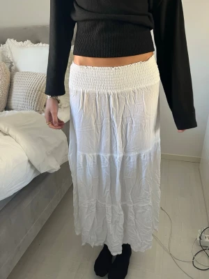 Vit långkjol  - Säljer en vit långkjol som är från lager 157. Den är aldrig använd. Kjolen har en luftig och flowy känsla, perfekt för varmare dagar. Passar till både enkla och mer uppklädda outfits.