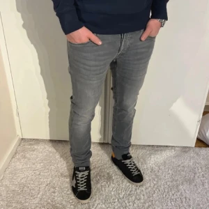 Replay anbass - Säljer ett par grå slim fit jeans från replay med modellen anbass. Jeansen har klassisk femficksmodell, normalhög midja och dragkedjegylf. Snygg tvätt med lätt slitning och raka ben. Perfekta till sneakers och hoodie.