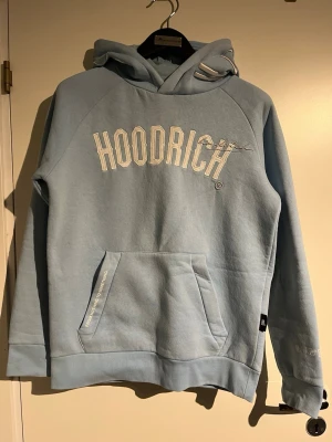 Ljusblå hoodie från Hoodrich - Original Hoodrich hoodie for men in size xs Light blue color with embroidered details and logo.	Men’s model, Size: xs, Condition: Used but in good condition (no major flaws)  Feel free to message me if you have any questions or want more pictures 😊