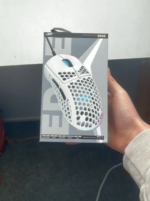 Lättvikts gamingmus JLT EDGE - Säljer en vit JLT EDGE ULTRA LIGHT gamingmus med honeycomb-design och RGB-belysning. Ny kostar den 499kr på Elgiganten  Den väger lilla 62 gram vilket gör den till en av de lättaste mössen. Musen har en ergonomisk form, sladd och två sidoknappar. Perfekt för snabba rörelser och gaming tack vare den låga vikten och flexibla kabeln.