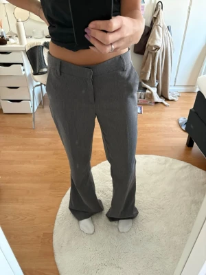 Gina Tricot Grey Tailored Trousers / Dress Pants - Description: Elevate your wardrobe with these sleek gray suit trousers from Gina Tricot in size 36. These have a beautiful fit that is perfect for professional settings or a chic casual look.  Condition: Like new! Only worn a maximum of five times.  Size: 36.  Color: Classic mid-gray.  Details: High-quality fabric with a tailored silhouette and a slightly flared leg.  These are in pristine condition with no signs of wear. A staple piece for any Scandi-inspired closet!